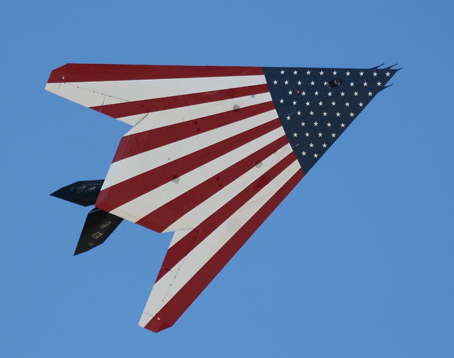 F-117 Nighthawk 'stealth fighter' with USA flag underside   (click here to open a new window with this photo in computer wallpaper format)