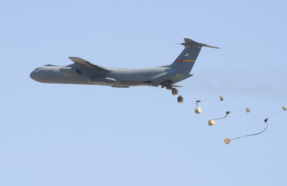 C-141 Starlifter dropping containers by parachute   (click here to open a new window with this photo in computer wallpaper format)