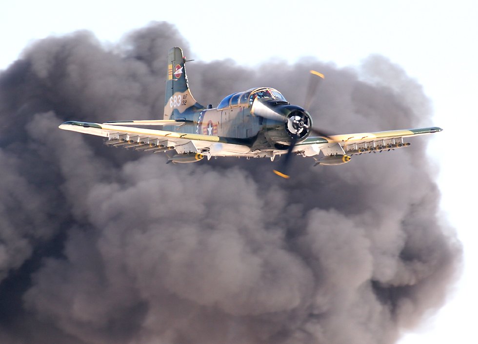 A-1 Skyraider with smoke cloud   (click here to open a new window with this photo in computer wallpaper format)