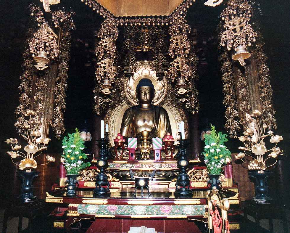 sitting Buddha statue surrounded by gold plated ornaments