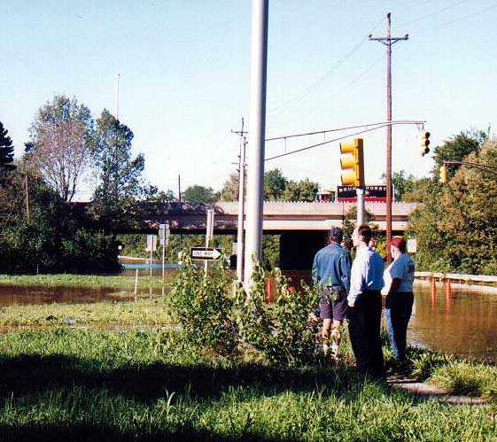 Motorists standing around looking wistfully at the freeway on ramp.