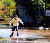 kid on rollerblades going down flooded street